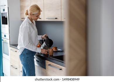 Pretty Lady Making Tea In The Kitchen Stock Photo