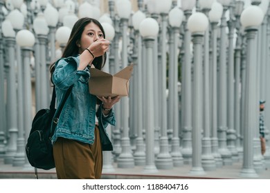 Pretty Lady Standing In Front Of The Los Angeles County Museum Of Art And Eating, She Is To Busy To Sit Down And Enjoy Her Dish