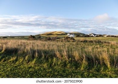 Pretty landscape of field and small traditional houses on Havre-aux-Maisons Island seen during a sunny fall morning, Magdalen Islands, Quebec, Canada