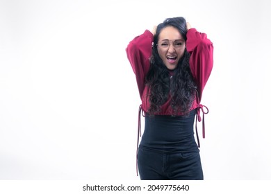Pretty Latin Hispanic Woman With Long Thick Hair Wearing Glasses On White Background Indoors Making Expressions And Gestures, Screaming, Distressed, Desperate, With Hands In Hair