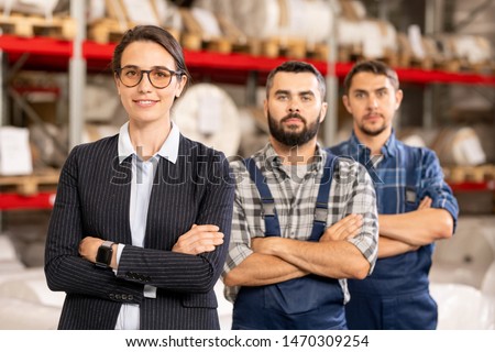 Pretty leader of workteam and two engineers crossing arms by chest