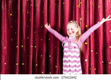 Pretty Little Blond Girl In Pantomime Costume Standing On Stage Playing To The Audience With Her Arms Outstretched And A Big Smile