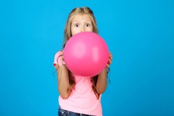 Pretty Little Girl Blowing Pink Balloon On Blue Background