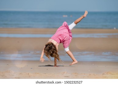 pretty little girl doing antics on the sunny beach - Powered by Shutterstock