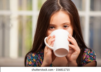 Pretty little girl drinking hot chocolate and relaxing at home - Powered by Shutterstock