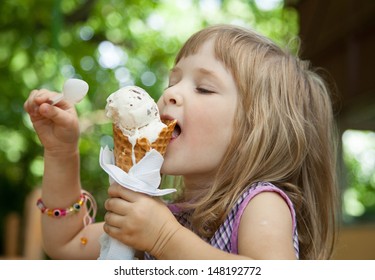 Hübsches kleines Mädchen, das draußen ein Eis isst
