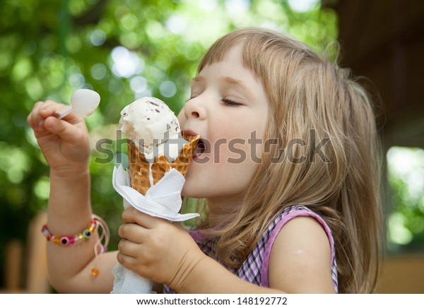 戸外でアイスクリームを食べているかわいい女の子 の写真素材 今すぐ編集