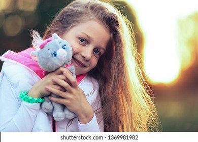 Pretty Little Girl Hugging A Favorite Stuffed Animal - A Cat For