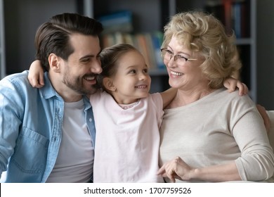 Pretty Little Girl Looking With Love At Elderly Grand Mother Hugs Father Multi-generational Family Enjoy Communication, Three Generations Relatives People Spend Time At Home, Warmth Connection Concept