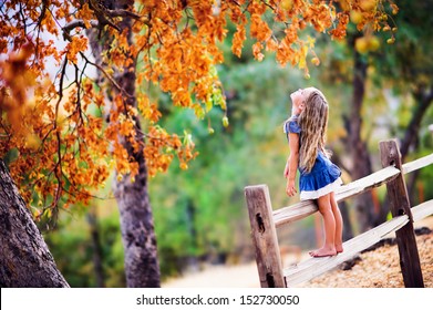 Pretty little girl relax on beauty autumn landscape background - Powered by Shutterstock