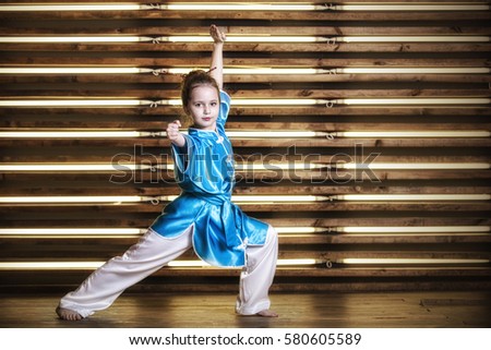 Pretty little girl in the room in sportswear for martial arts is Wushu or kung fu