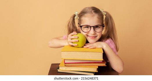 Pretty little girl schoolgirl with books and apple. School concept. Back to School. World books day.