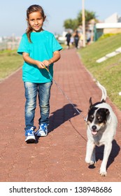 Pretty Little Girl Walking A Dog Outdoors