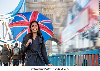 Pretty London Traveler Woman With A British Flag Umbrella Walks On The Tower Bridge During A Sightseeing Trip