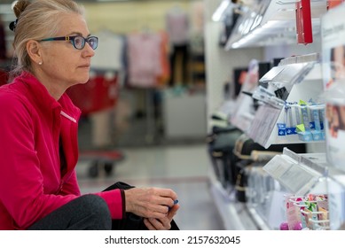 Pretty Mature Middle Age Woman Shopping For Makeup In A Bright Airy Big Box Store.