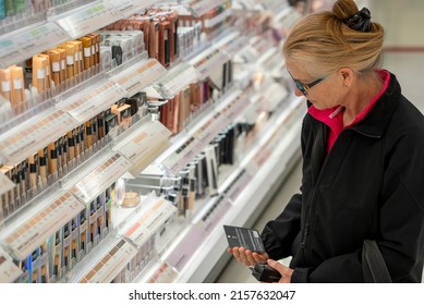 Pretty Mature Middle Age Woman Shopping For Makeup In A Bright Airy Big Box Store.