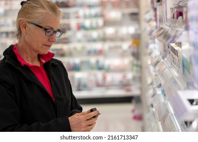 Pretty Mature Middle Age Woman Shopping For Makeup In A Bright Airy Big Box Store.