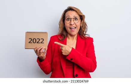 Pretty Middle Age Woman Looking Excited And Surprised Pointing To The Side. Calendar Concept