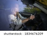 Pretty midle aged woman at the steering wheel of her car, going fast