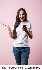 Pretty Millennial Indian Girl Isolated On Pink Studio Background Text Messaging On Cell Phone Or Using Smartphone With Wireless Connection