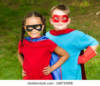 Pretty mixed race girl and Caucasian boy pretending to be superhero - Powered by Shutterstock