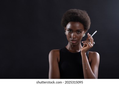 Pretty Model African American Woman Smoking Cigarette On Black Background.