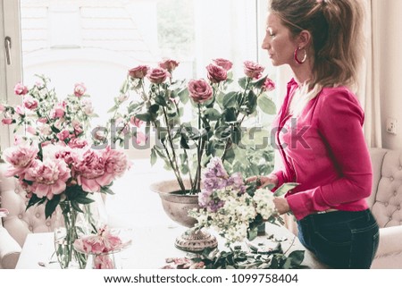 Similar – Woman arranges flower bouquet with roses in vase