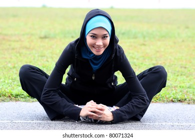 A Pretty Muslim Woman Athlete Stretching Her Body At Stadium Track