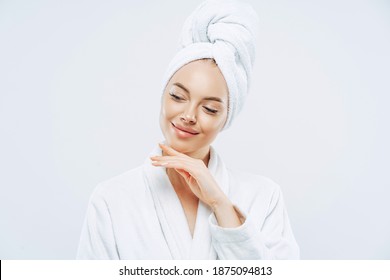 Pretty Natural Woman Touches Gently Jawline, Wears Bath Towel Wrapped On Head, Dries Hair After Shower, Cares About Body, Has Clean Skin, Prepares For Evening Party, Dressed In Domestic Robe