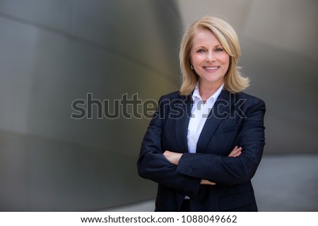 Pretty older business woman, successful confidence with arms crossed in financial building