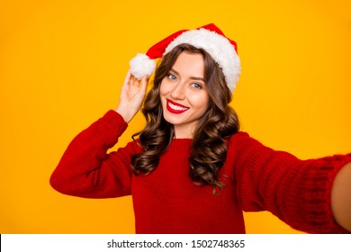 Pretty overjoyed lady making selfies wear knitted sweater and santa hat isolated yellow background