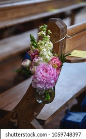 Pretty Pastel Church Flowers Hanging On A Pew For A Wedding