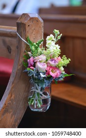 Pretty Pastel Church Flowers Hanging On A Pew For A Wedding