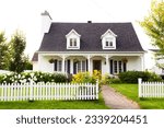 Pretty petite ancestral neoclassical white clapboard house with shingled roof and picket fence in the Ste-Foy area, Quebec City, Quebec, Canada