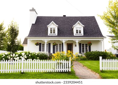 Pretty petite ancestral neoclassical white clapboard house with shingled roof and picket fence in the Ste-Foy area, Quebec City, Quebec, Canada