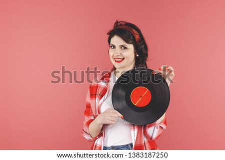 Pretty pin up woman with vinyl isolated over thered backgruond.