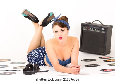 Pretty Pinup Girl Sending A Kiss Lying On The Floor With Vynil Records And A Speaker Isolated On White