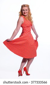 pretty pinup model in a red and white polka-dot dress