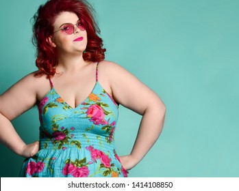 Pretty plus-size fat woman in fashion sunglasses with enigmatic mysterious face looks at us like she suspects us of prank or trick on mint background