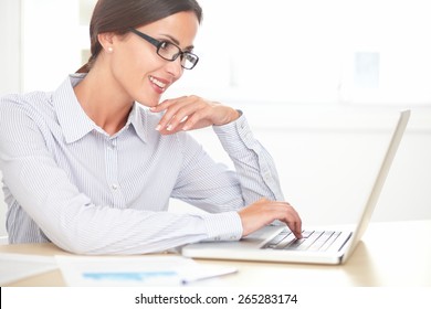 Pretty professional secretary in blue blouse using the laptop