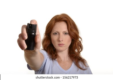 Pretty red-haired woman with pepper spray, Studio Shot