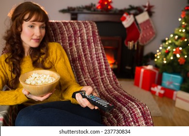 Pretty Redhead Watching Television On Couch At Christmas At Home In The Living Room