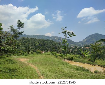 Pretty Scenery Of Mountains, Green Grass, Blue And Cloudy Sky From Sentul, West Java, Indonesia