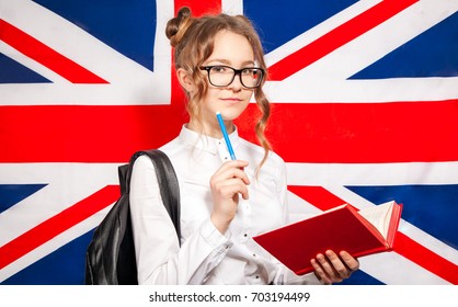 英語学習コンセプト 英語の国旗の背景にノートを掲げ カラフルなコピー本を手で閉じ カラフルな写し本を持つ興奮した男性のポートレート の写真素材 今すぐ編集