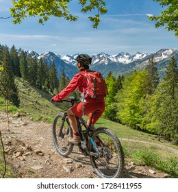 pretty senior woman riding her electric mountain bike on the Wallraff Trail in the Nebelhorn area above  Oberstdorf, Allgau Alps, Bavaria, 