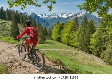 pretty senior woman riding her electric mountain bike on the Wallraff Trail in the Nebelhorn area above  Oberstdorf, Allgau Alps, Bavaria, 