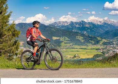 pretty senior woman riding her electric mountain bike on the mountains above the Iller valley between Sonthofen and Oberstdorf, Allgau Alps, Bavaria Germany