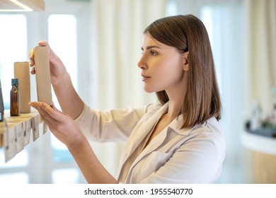 Pretty shop assistant examining new products and looking involved - Powered by Shutterstock