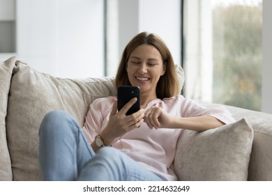 Pretty Single Woman Relaxing On Cozy Sofa With Modern Smart Phone Having On-line Communication Use E-date Services, Makes Call, Enjoy Social Media Chat Spend Leisure Alone At Home. Wireless Tech, Apps