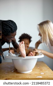 Pretty Small Child Takes Bath. Parents Bathe The Baby. Pretty Baby. Family At Home. Adorable Black Child Enjoy, Relax Bathing, Have Fun. Skincare, Hygiene Concept. Focus On Feet